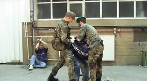 Two soldiers are humiliating their obedient victim
