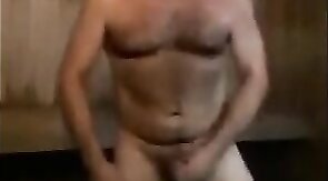 Un mec musclé se branle en extérieur dans un sauna
