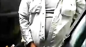 Bearded daddy strokes his cock by his truck outdoors.