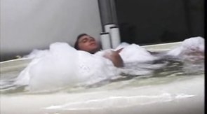 Soapy man with tanned skin shows off his beach body