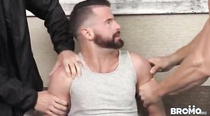 Two masked men are fucking a bearded cocksucker