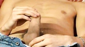 Relaxed lad jerks off his pole on a leather chair