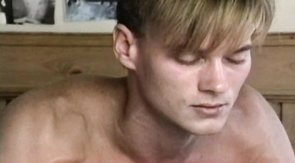 Sporty lover is playing with boner in the bedroom