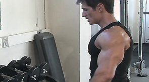 Muscular man with huge cock is posing in the gym