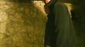 Three guys dominating a twink in a dark cellar