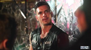 Two leather-clad dudes making out during a shootout