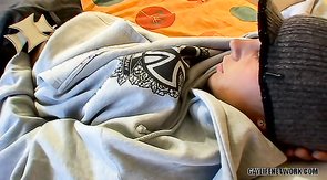 Twink in baggy clothes stroking his lovely cock on a bed