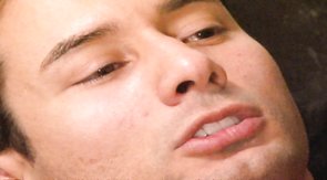 Bald black athlete gives a good interracial blowjob in the bed