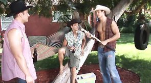 Sexy cowboys are playing with each other's dicks on the grass