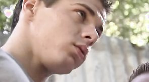 Beautiful young lover is standing on the knees and sucking two dicks