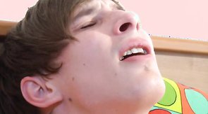 Brunette twink with longish locks deepthroats a meaty cock