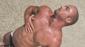 Bodybuilder shows his muscles and big cock in sunlight