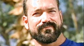 Bodybuilder shows his body off while bear prepares his meat