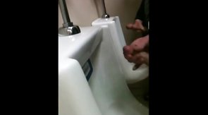 two slim dicks getting wanked at the urinals