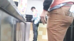 Guys in the urinals taking leak.