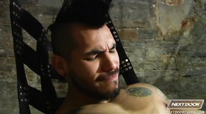 Chained black cocksucker is getting fucked by two hunks