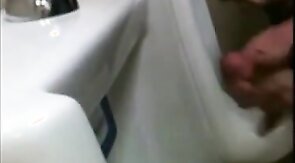 two slim dicks getting wanked at the urinals