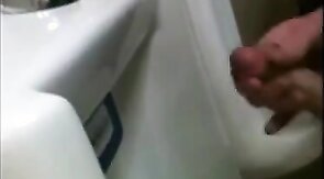 two slim dicks getting wanked at the urinals