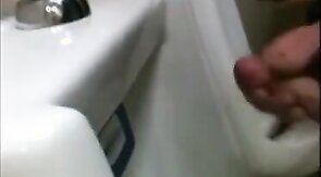 two slim dicks getting wanked at the urinals