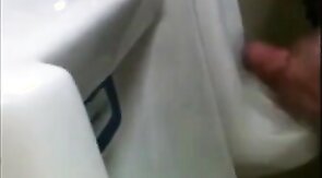 two slim dicks getting wanked at the urinals