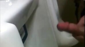 two slim dicks getting wanked at the urinals