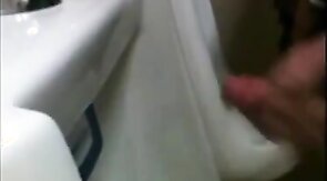 two slim dicks getting wanked at the urinals