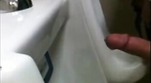 two slim dicks getting wanked at the urinals