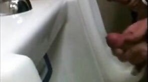 two slim dicks getting wanked at the urinals