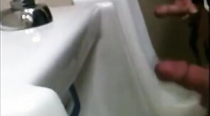 two slim dicks getting wanked at the urinals