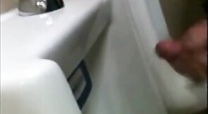 two slim dicks getting wanked at the urinals