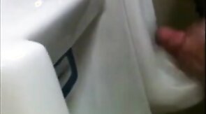two slim dicks getting wanked at the urinals