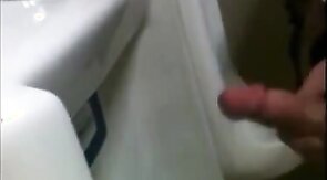 two slim dicks getting wanked at the urinals