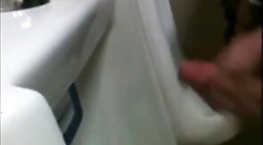 two slim dicks getting wanked at the urinals