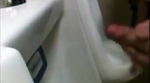 two slim dicks getting wanked at the urinals