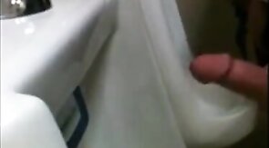 two slim dicks getting wanked at the urinals